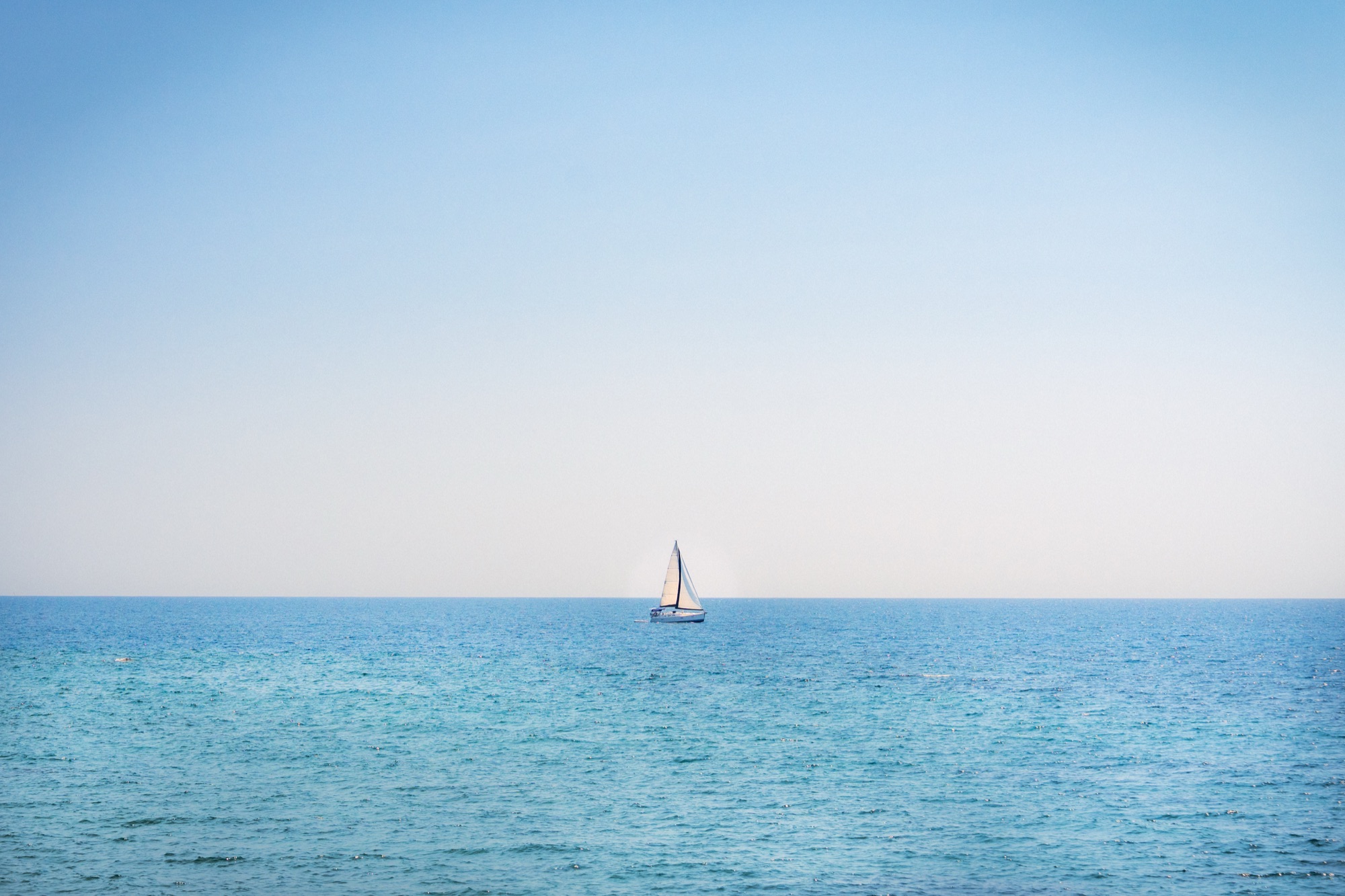 Lone sailboat on calm open sea