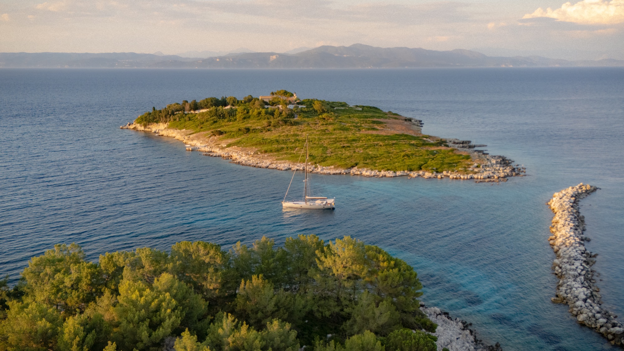 Sailboat anchored near a green island