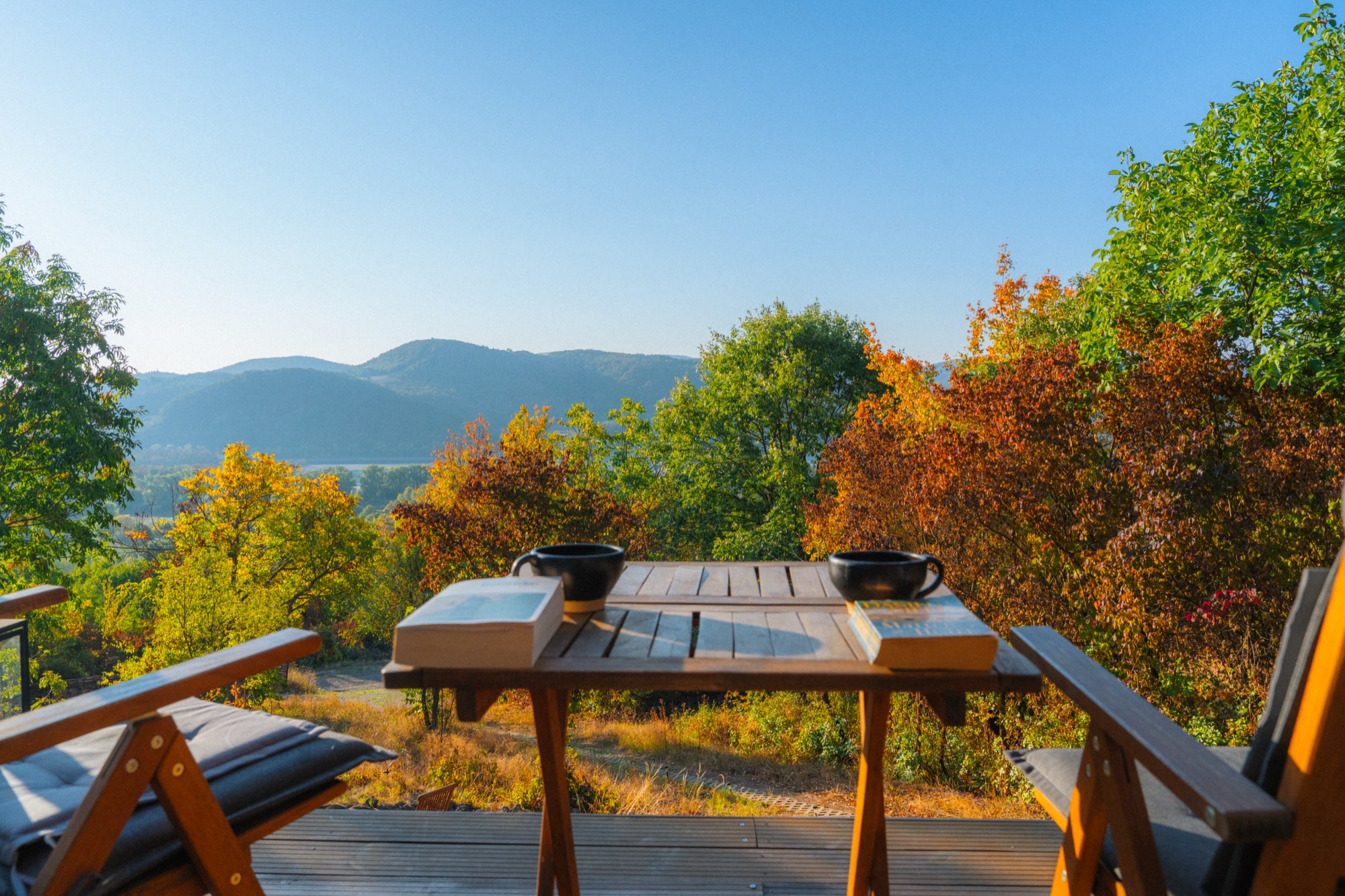 Deck table set with coffee and bread looking out to the hills