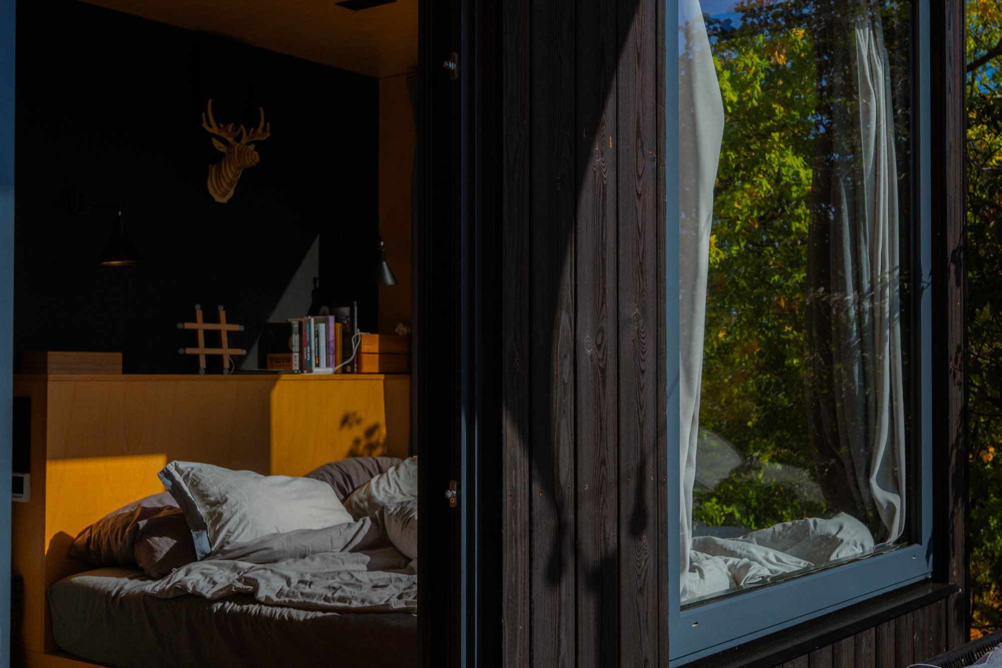 Dark bedroom interior lit only by the last of the evening light