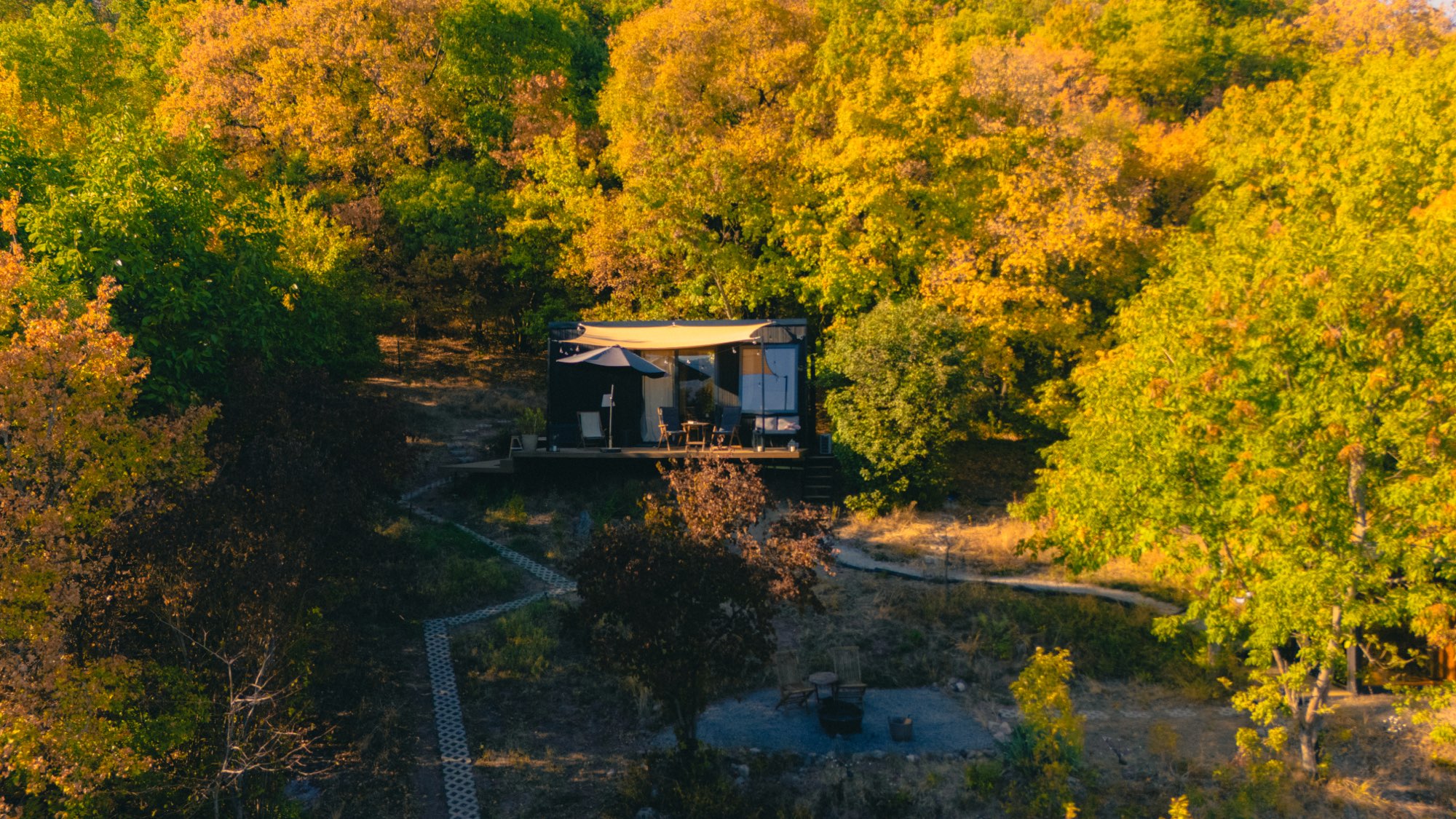 Aerial view of the cabin tucked among golden autumn trees