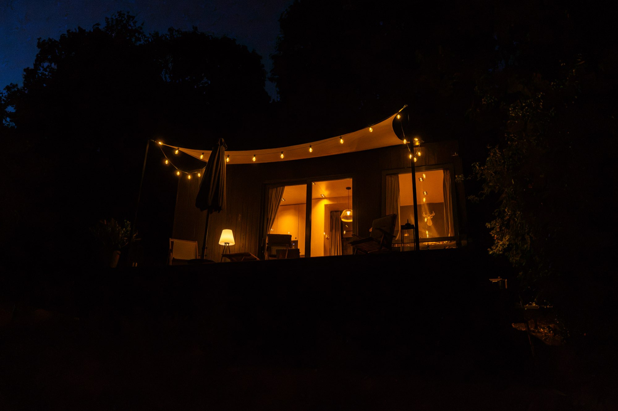 The cabin lit up after dark under its string lights
