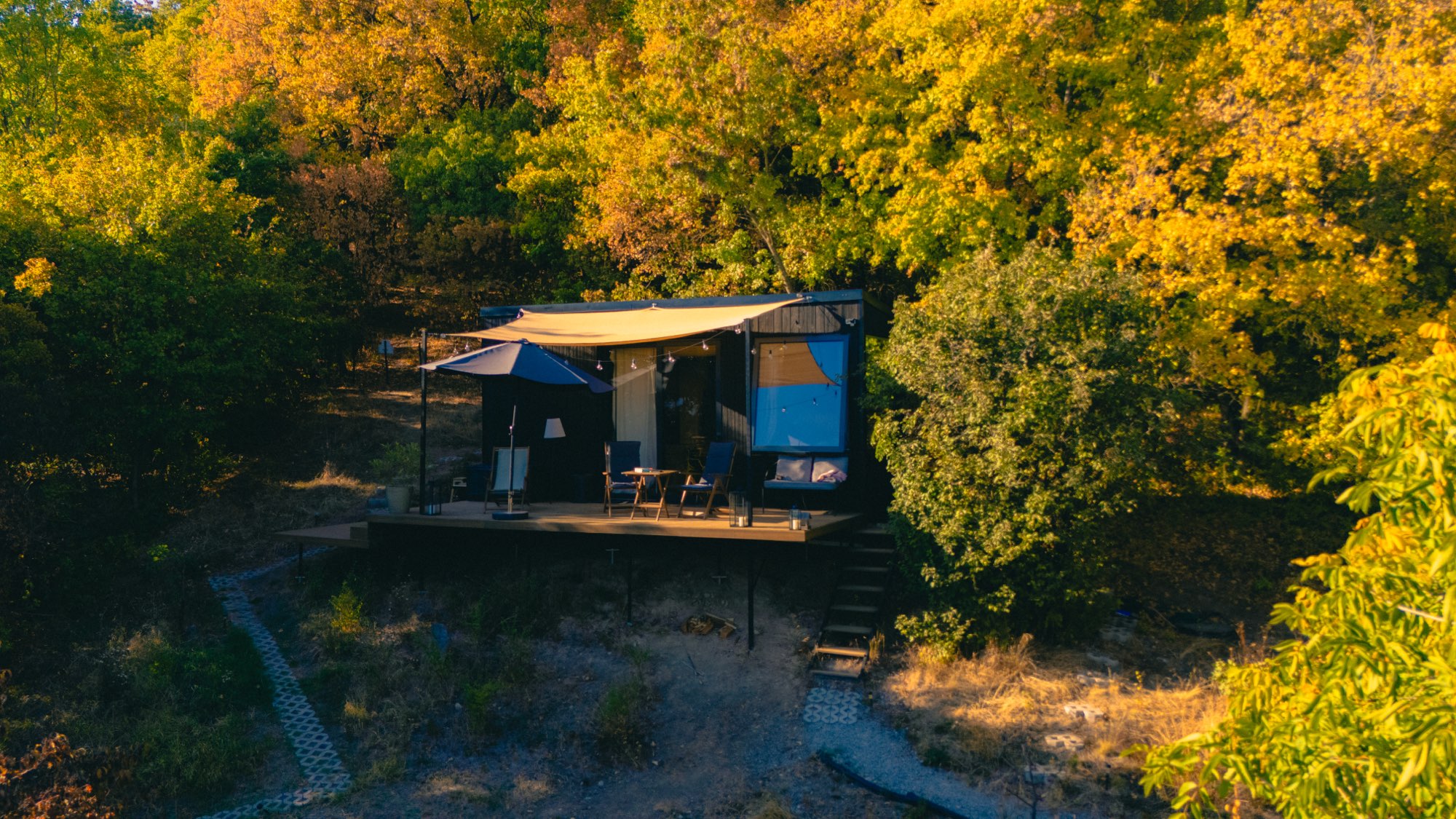 Aerial view of the cabin deck and shade canopy from above the treeline