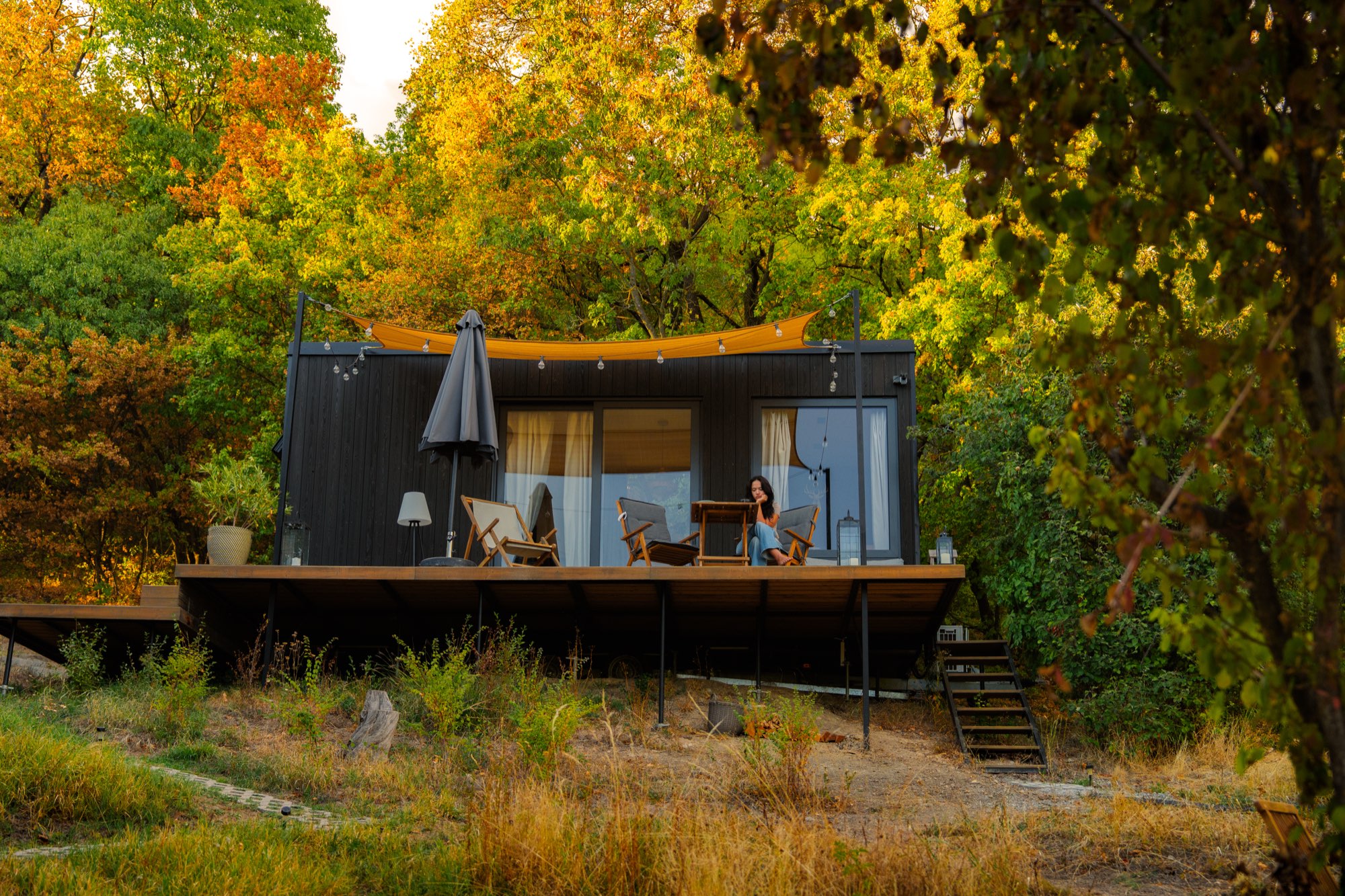 Cabin exterior in golden hour light surrounded by turning trees